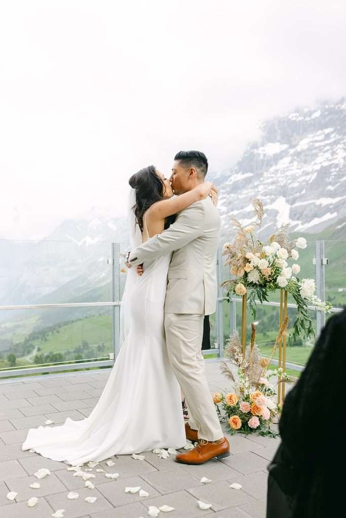 The first kiss of a bride and groom during their intimate wedding ceremony in Switzerland.