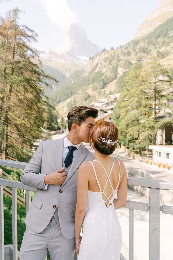 A couple kissing each other in front of the Matterhorn.