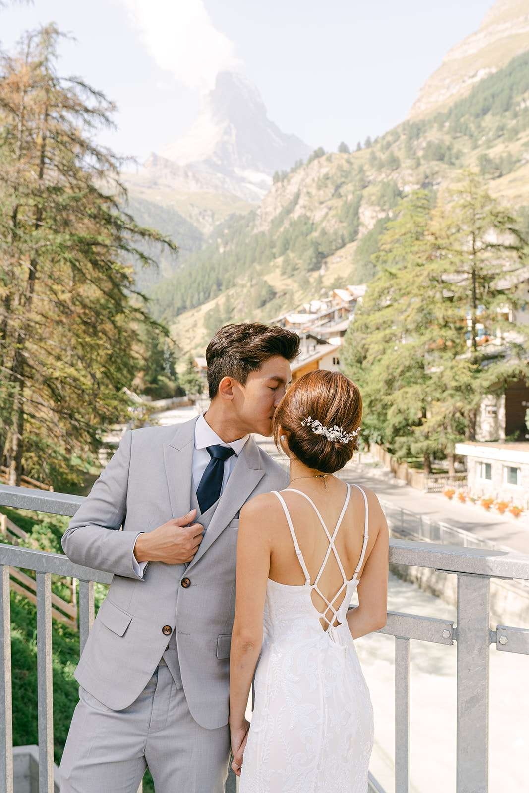 A couple kissing each other in front of the Matterhorn.