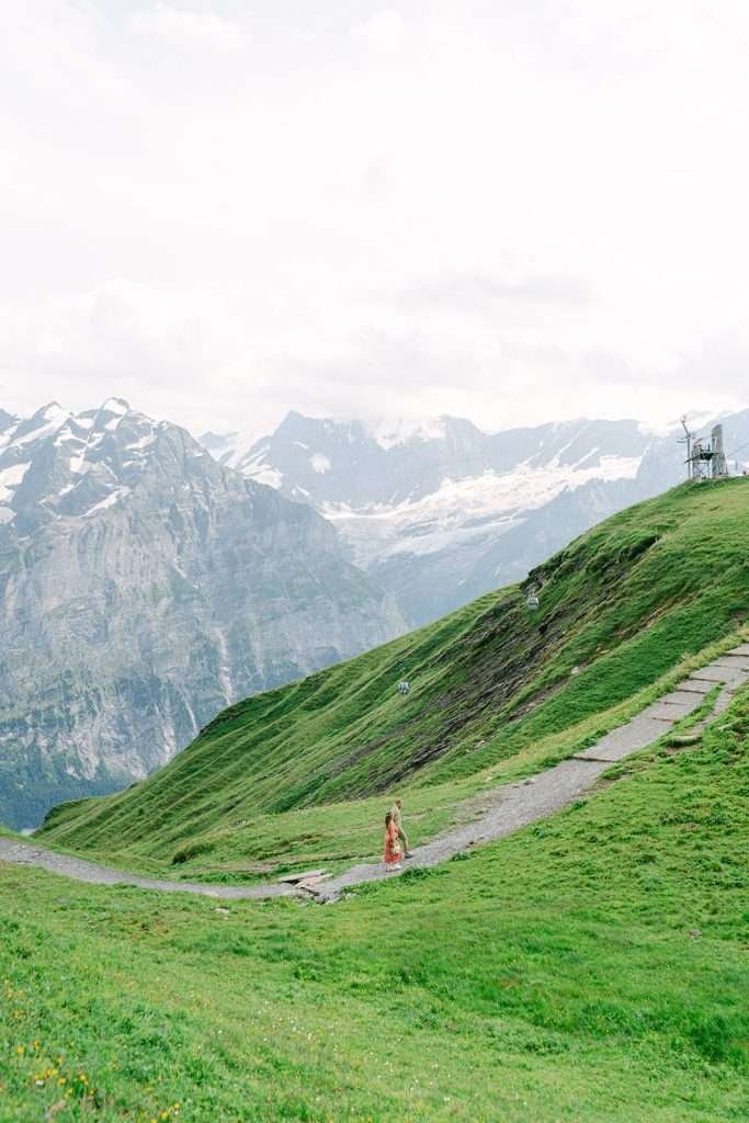 A couple walking in the middle of Grindelwald during their engagement photo session.