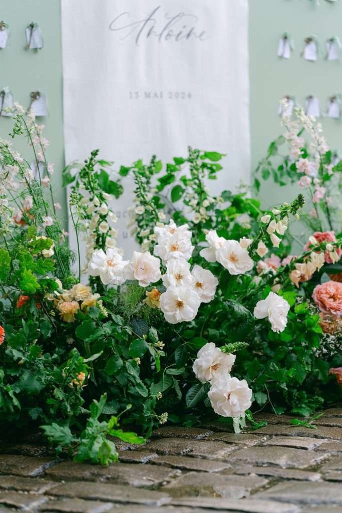 White flowers set up for a wedding ceremony by a welcome sign