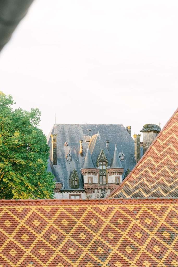 A peak over an ornate roof to the stunning Domaine de Bournel wedding venue