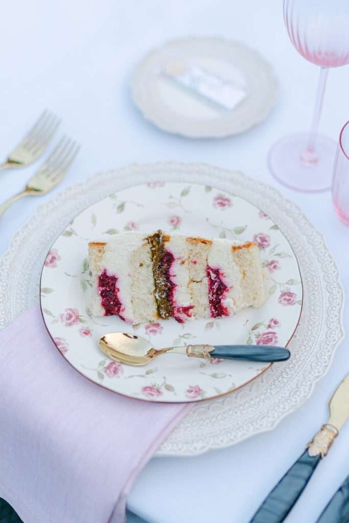 Details of a cake served with gold utensils on a floral plate