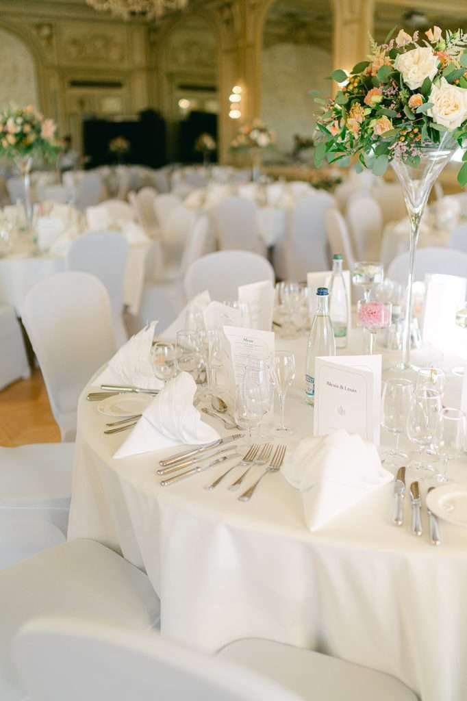 Details of a wedding reception table with white linens and napkins