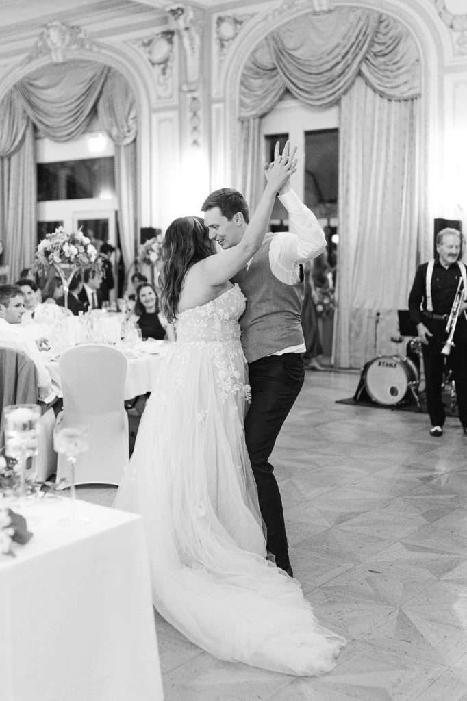 A black and white image of newlyweds dancing during their wedding reception