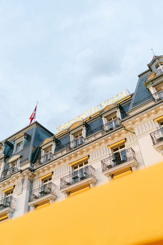 A look up from the street at the neon sign of Grand Hotel Suisse Majestic