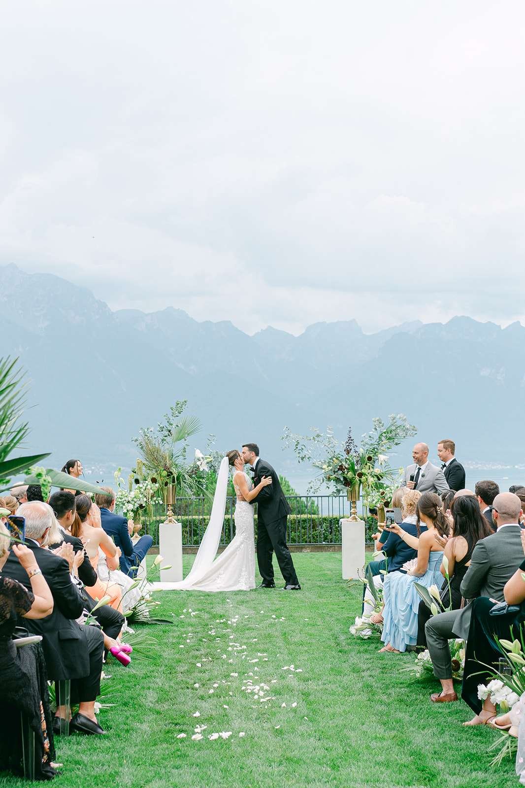 Newlyweds kiss to end their outdoor ceremony with an epic backdrop at their destination wedding in Switzerland