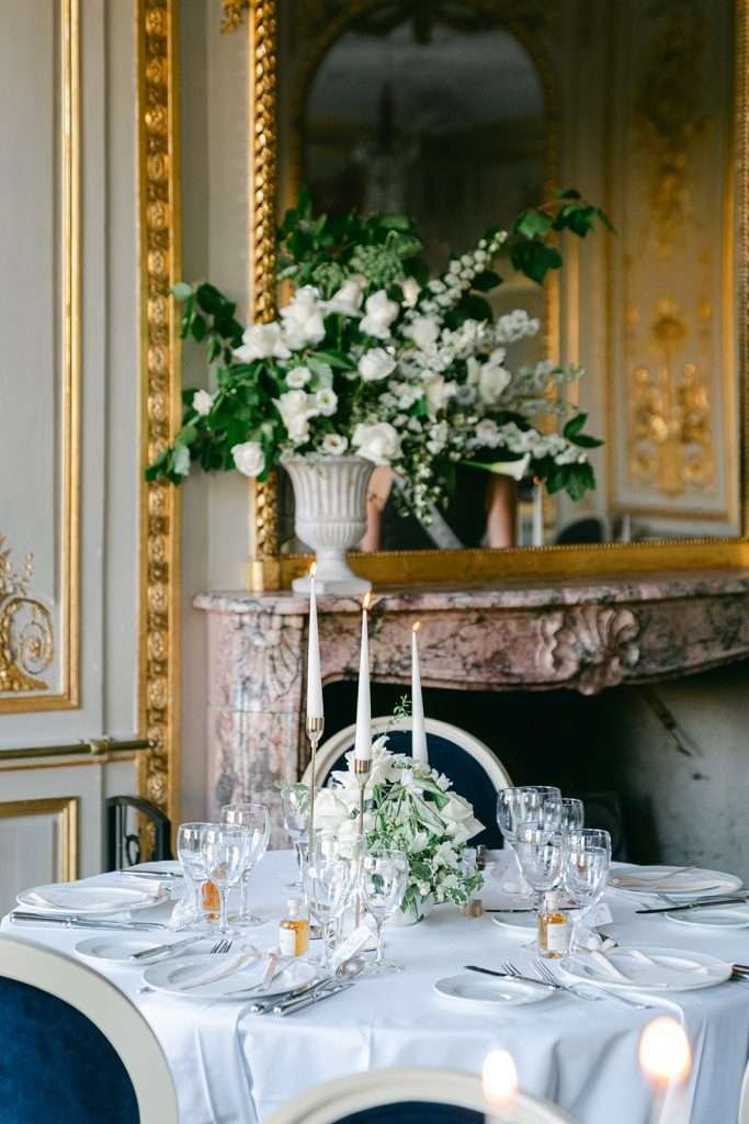 Details of a table setting in front of a marble fireplace