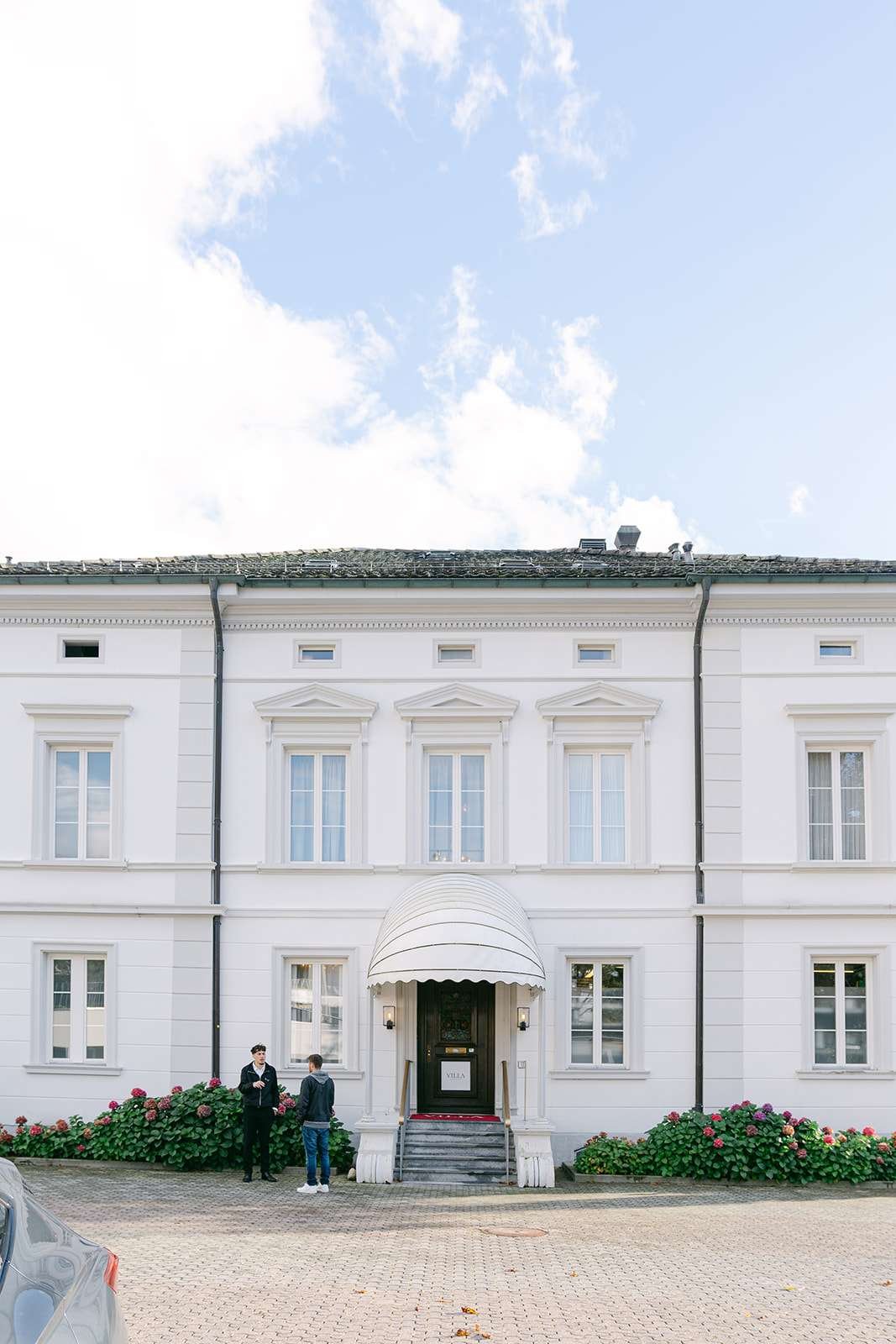 A look straight on at the front facade of a wedding venue with flowers in the garden